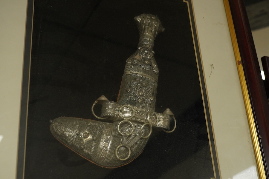 A glass framed white metal khanjar and a similar dhow, together with part model of a Dallah, 16.3cm.